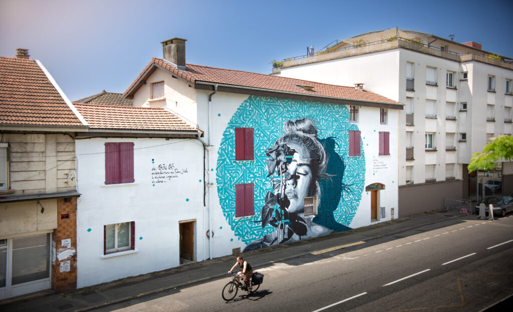 peinture murale représentant un portrait de femme recouvert d'une rose et avec de la calligraphie turquoise autour